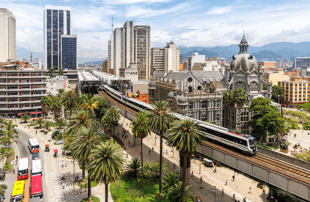 La imagen muestra el sistema de transporte masivo Metro de Medellín en Colombia, pasando cerca del Palacio de la Cultura Rafael Uribe Uribe.